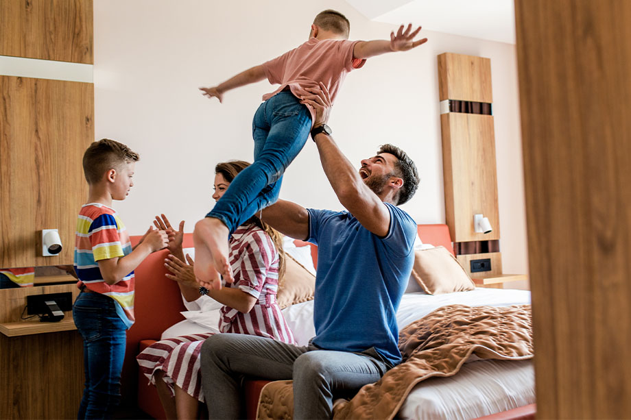 A family playing happily in bedroom setting